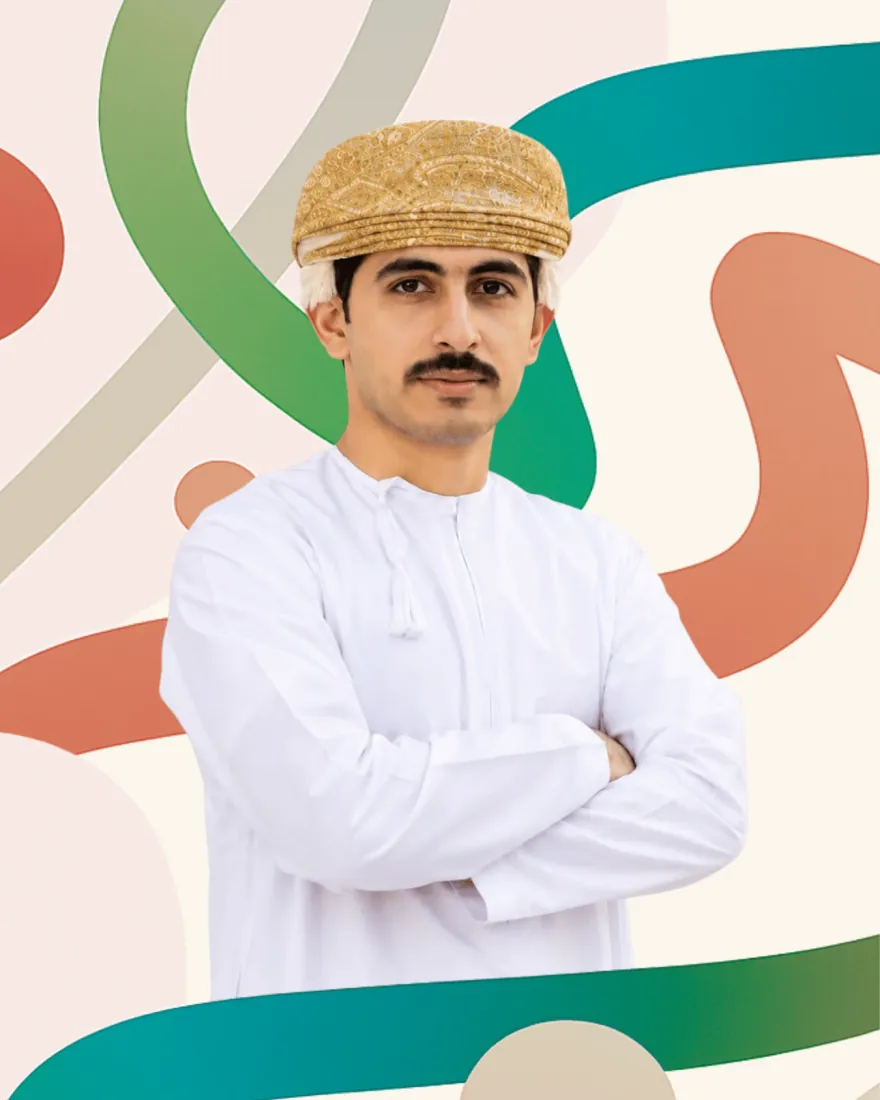 شابّ يرتدي الزيّ العُماني أمام خلفية بأشرطة من ألوان جهبذ